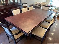 View of extended rectangular dining table with ten chairs arranged around.