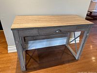 Full side view of the wood console table showing wood grain top, drawer with metal pull, and cross-braced legs.