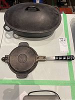 Closed view of oval cast iron pot with lid and waffle iron beneath