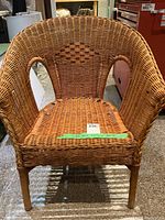 Front view of rattan wicker chair showing woven diamond shape pattern on backrest.