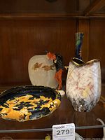 All five items displayed on glass shelf: three vases, decorative dish and figurine
