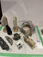 Wide view of all small statues, marble bookends, bird sculpture, and other decorative items on white surface