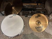 Evans snare drum head and stacked Sabian cymbals with hardware stands in background
