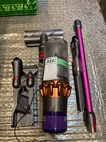 Full overview of vacuum components laid out: main unit with dust bin, torque drive head, wand, dock, and tools.