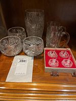 Overview of serving bowls, vase, beer glasses, and boxed small condiment serving dishes with spoons.