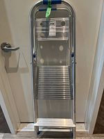 Front view of aluminum step ladder showing two steps and top platform, blue plastic accents on handle and steps.