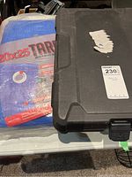 Socket set case closed next to the folded blue tarp on a table