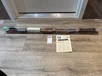 Full view of the model train set in plexiglass display case with all cars visible including locomotive and freight cars.