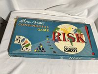 Closed game box with blue background, large globe graphic and 'RISK' text, showing vintage design and some corner wear.