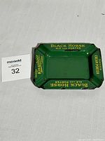 Green rectangular enamel ashtray showing black horse ale and porter advertising, Dawes Kingsbeer Lager and Dawes Cream Porter text in yellow lettering