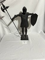 Full front view of the approximately 22-inch tall metal knight statue standing with poleaxe and shield on a base.