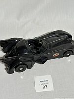 Top side view of vintage plastic Batmobile toy car with Batman logo on door and cockpit open showing steering wheel and interior details.