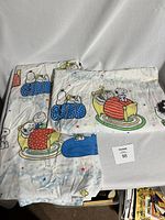 Photo of all three bed sheet set pieces showing colorful Peanuts characters designs including Snoopy and Charlie Brown