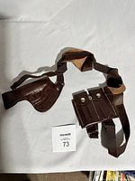 Full view of the vintage brown leather RCMP detective holster with attached belt and detachable ammunition pouch with two snap button closures.
