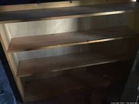 Front view of solid pine bookcase with three shelves, showing used condition with crayon marks on shelves and back.