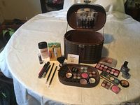 Overview photo of cosmetic case with open lid, showing new beauty products arranged in front and inside case