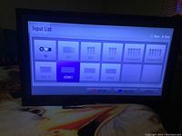 TV showing input selection menu including options like TV, USB, AV1, AV2, HDMI1 etc.