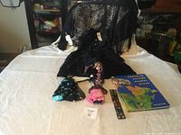 Lot overview showing doll, clothing, socks, belt and atlas