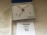 Full view of necklace and earrings displayed in box with label 'Genuine Austrian Crystal' visible.