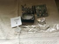 Full lot overview showing multiple jewelry items on a light surface including bracelets and necklaces.