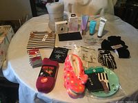 Wide view showing all assorted beauty, clothing, slippers, socks, accessories on table