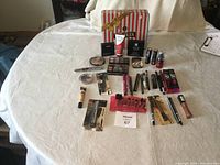 Overview of all cosmetics on a table including boxed and loose items, showing the lot's assortment and packaging variety.