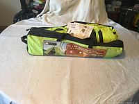 Photo showing full tent bag lying flat on a surface with the label indicating size and brand, with paperwork on top.