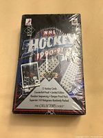 Front photo of sealed box showing branding, graphics and details about card quantity and special features.