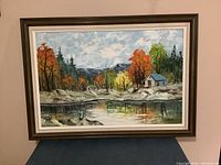 Full view of the Garett oil painting depicting a landscape scene with autumn trees, a cabin, and lake.
