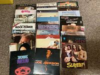 Overall view of front covers for 30 LP records laid out on carpet