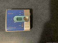 Front view of Sony MZ-N4200 Walkman showing blue and silver casing with volume slider and control buttons.