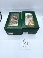 Two original green boxes of Dept 56 vintage collectible ornaments with clear plastic windows showing the contents inside, each titled 'Counting House & Silas Trimbleton Barnsiter'. Seller's lot number card labeled '6' included in photo.