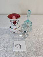 Photo of three vintage signed Fenton glass items on white surface: decorated vase, glass bell, and bear figurine.