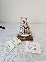 Front angle of vintage Giuseppe Armani figurine with original tags and wooden base with plaque