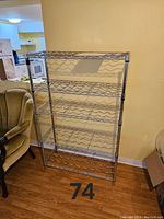 Full view of the chrome steel wire wine rack showing six shelves with wave pattern for holding wine bottles horizontally.