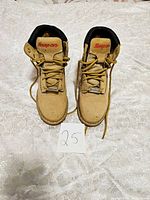 Front view of the pair of tan Snap-on work boots showing the red logo on the tongue and tan laces with size note '25'.