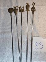 Full view of all five vintage metal skewers with distinctive decorative handles.