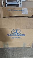 Closed cardboard box with Patterson branding and contact details.