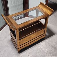 Full view of vintage wooden table with glass top and storage underneath