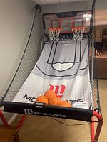 Front view of MD Sports arcade basketball game showing dual basketball hoops, playing surface, and four basketballs collected at the front.