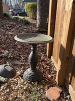 Side view of the metal birdbath showing base and basin.