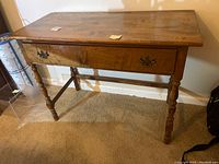 Front view of the full console table showing the single drawer, turned legs, and the overall structure.