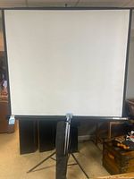 Front view of Apollo retractable media screen on tripod stand fully set up indoors