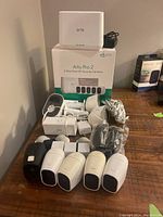Overview of Arlo Pro 2 base station on package, five cameras, charger, batteries, skins and mounts