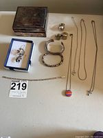 Full view of sterling silver jewelry pieces and jewelry box shown on table.