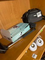 Canon PowerShot SD790 IS digital camera in original box, SelfiePAL selfie stick, Canon camcorder bag on wooden shelf