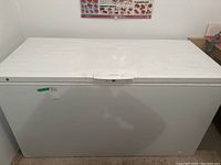 Closed view of white Frigidaire chest freezer showing lid and front panel with small scuffs.