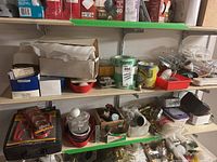 Photo showing two basement shelves containing various hardware and electrical supplies including tins and boxes, hardware parts, and tools.