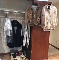 Full view of clothing items hanging on rack including jackets, blazers, and additional items below