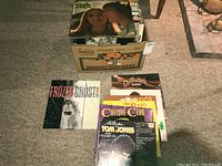 Photo of the box containing approximately 68 LP vinyl records, showing several album covers laid out in front including Chilliwack, B52s, Culture Club, and Frozen Ghosts.